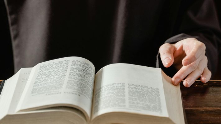 person reading book on brown wooden table