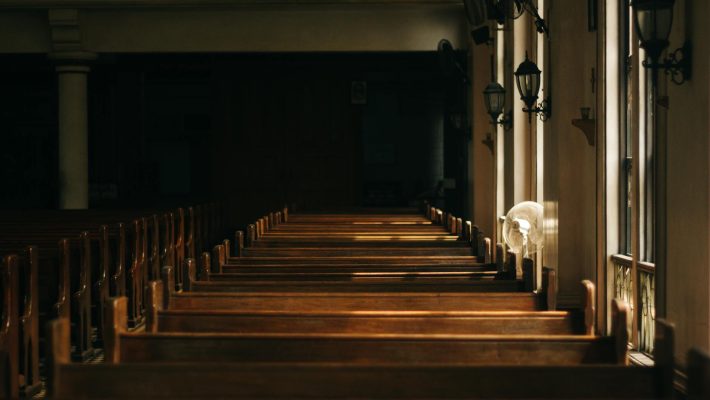 brown wooden church bench near white painted wall